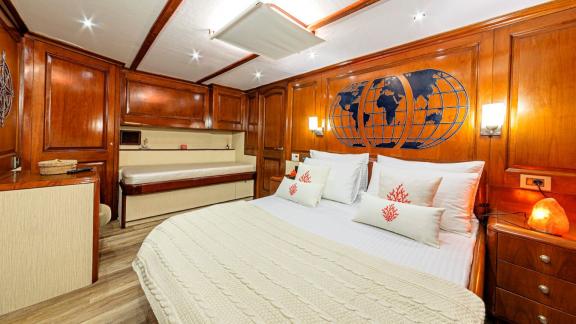 Spacious cabin with double bed, sofa and stylish wood panelling.